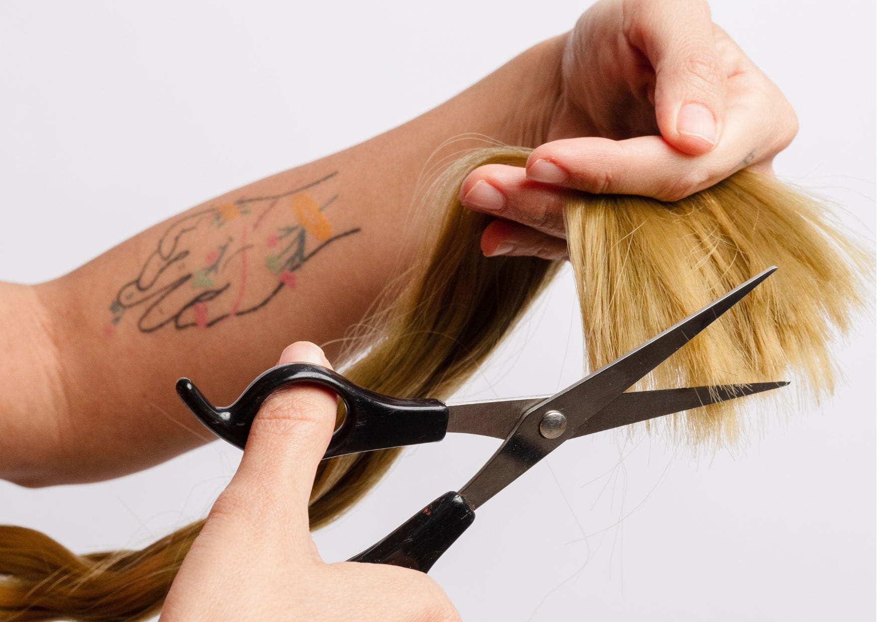 pessoa cortando as pontas danificadas do cabelo